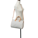 A stylish women's crossbody bag with a checkered pattern, featuring dual handles and an adjustable shoulder strap.