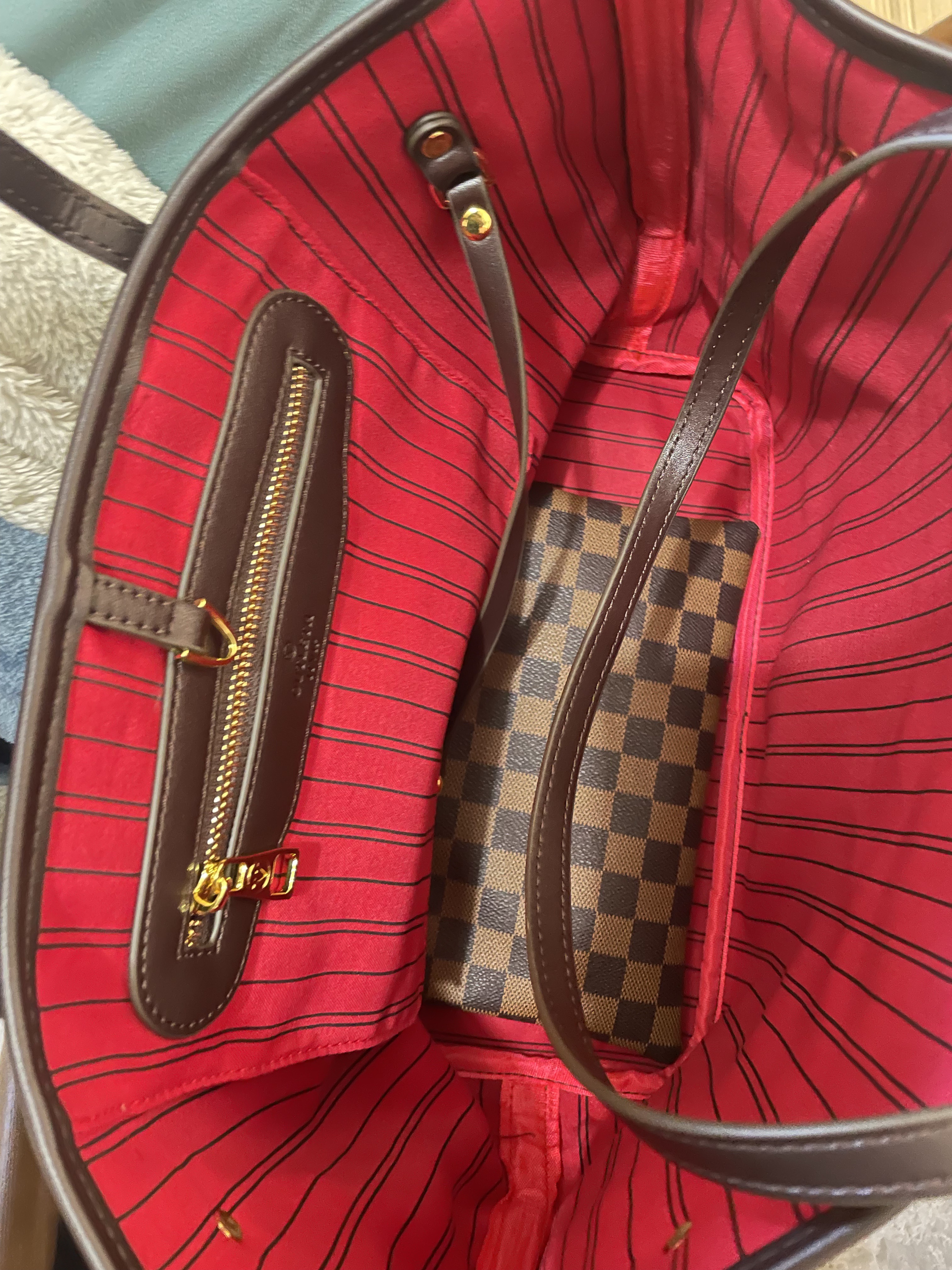 Classic brown Damier Ebene pattern, with a matching detachable pouch. Red striped lining + zippered pocket. Large capacity, metal hardware. Timeless, practical for daily use (shoulder/crossbody). A iconic luxury staple.